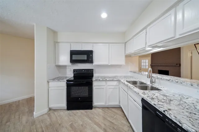 a kitchen with granite countertop a sink and steel appliances