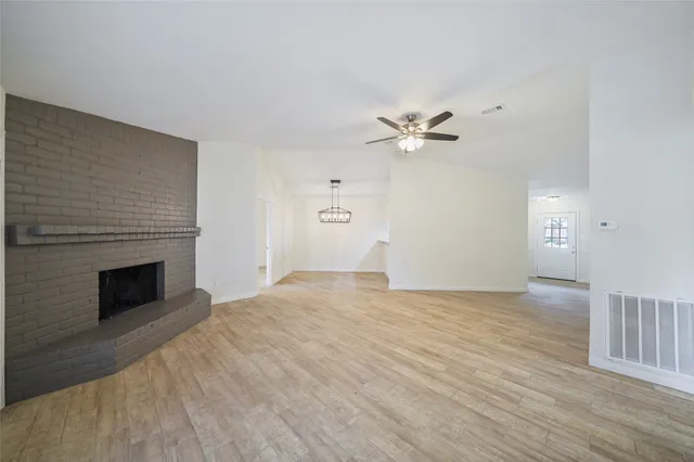 an empty room with fan and fireplace