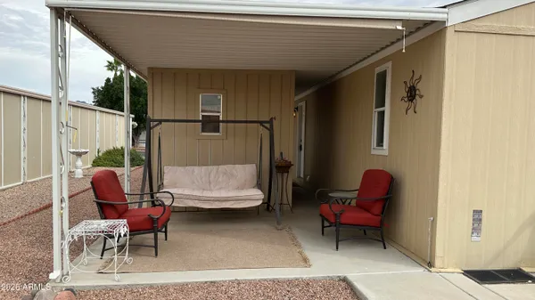 a backyard of a house with table and chairs plants