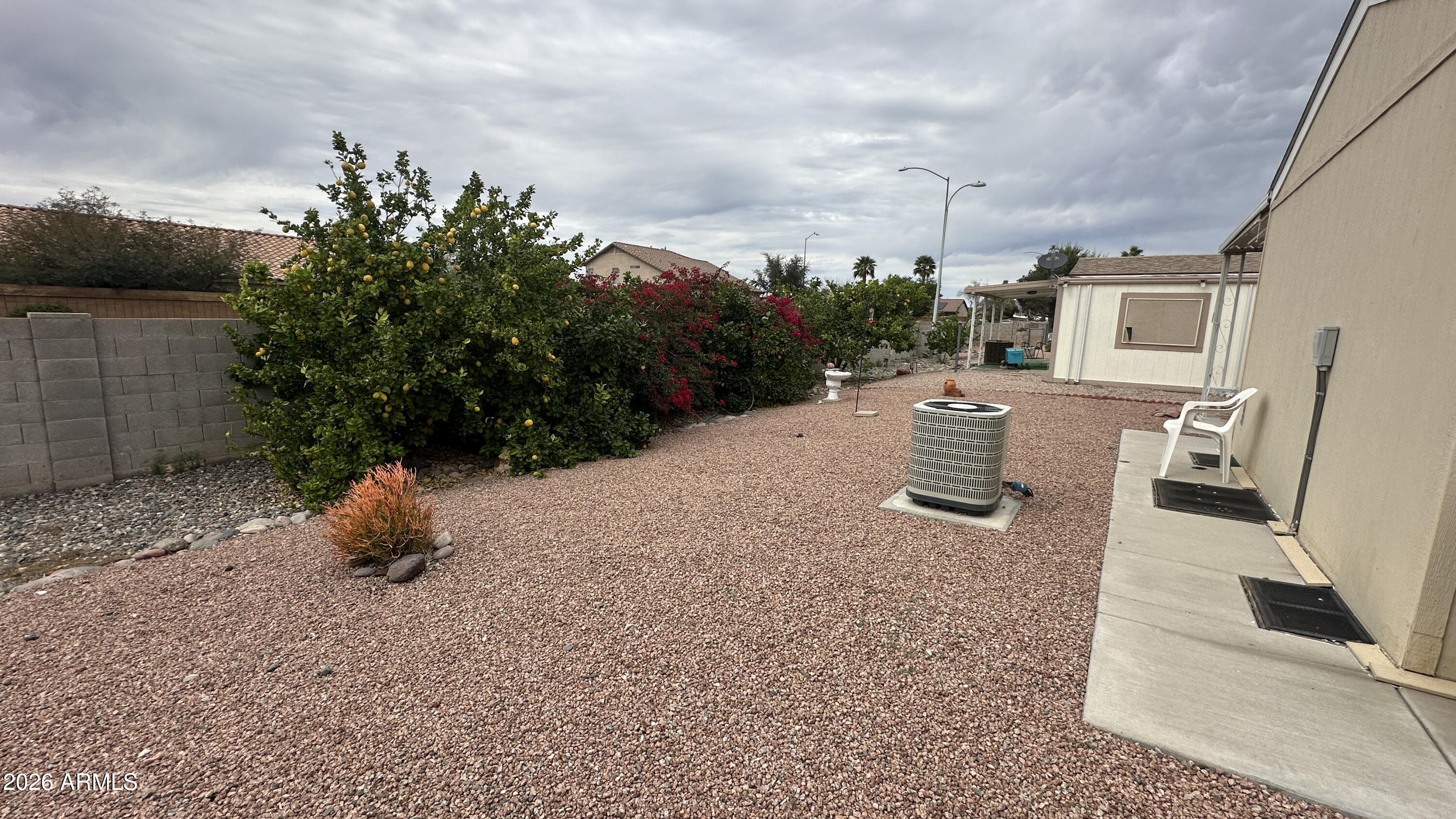 834 South Meridian Road, Unit 174 Apache Junction, AZ 85120 - Photo 18 of 56 a backyard of a house with table and chairs plants