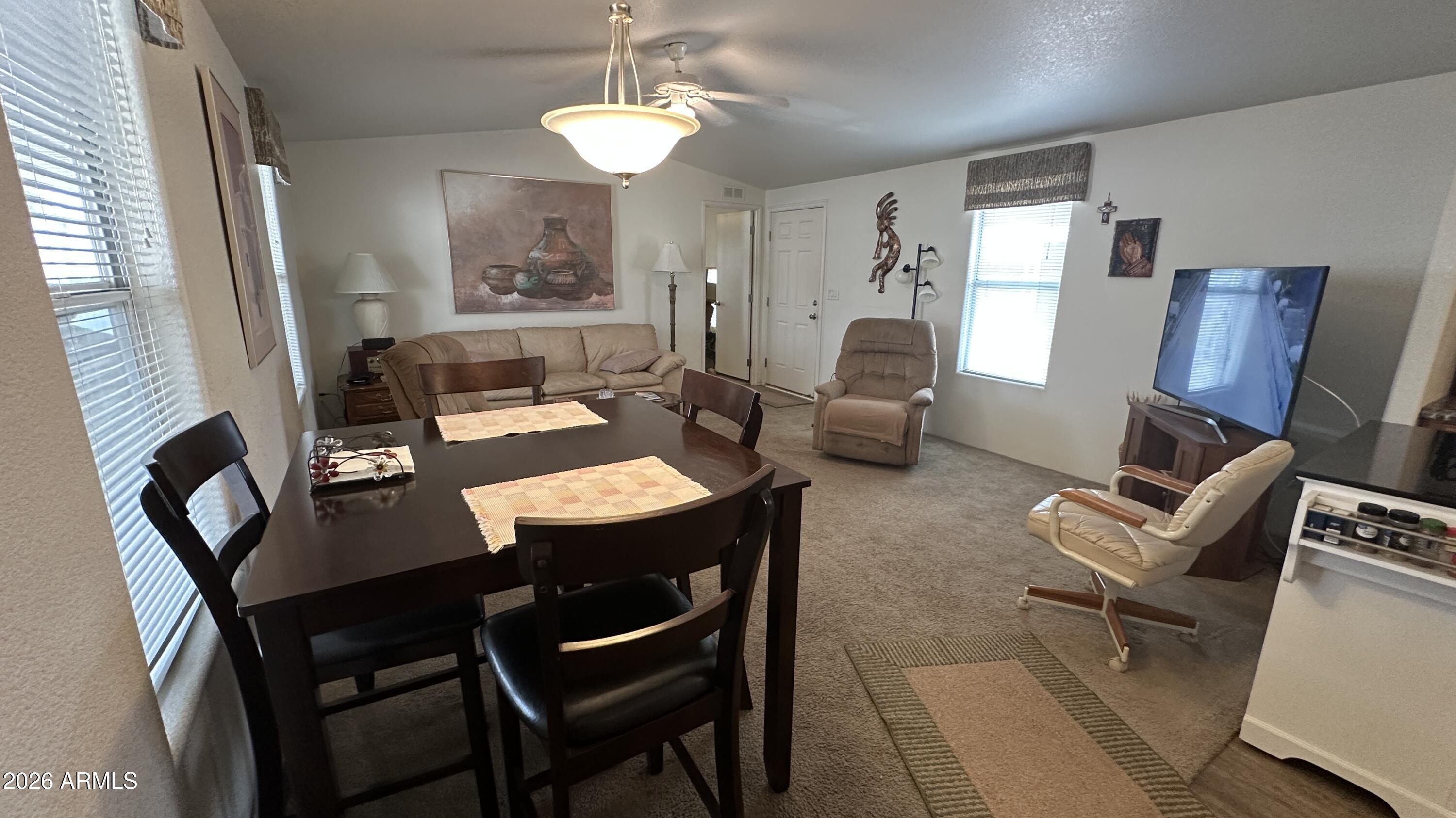 834 South Meridian Road, Unit 174 Apache Junction, AZ 85120 - Photo 33 of 56 a view of a dining room with furniture a chandelier and wooden floor
