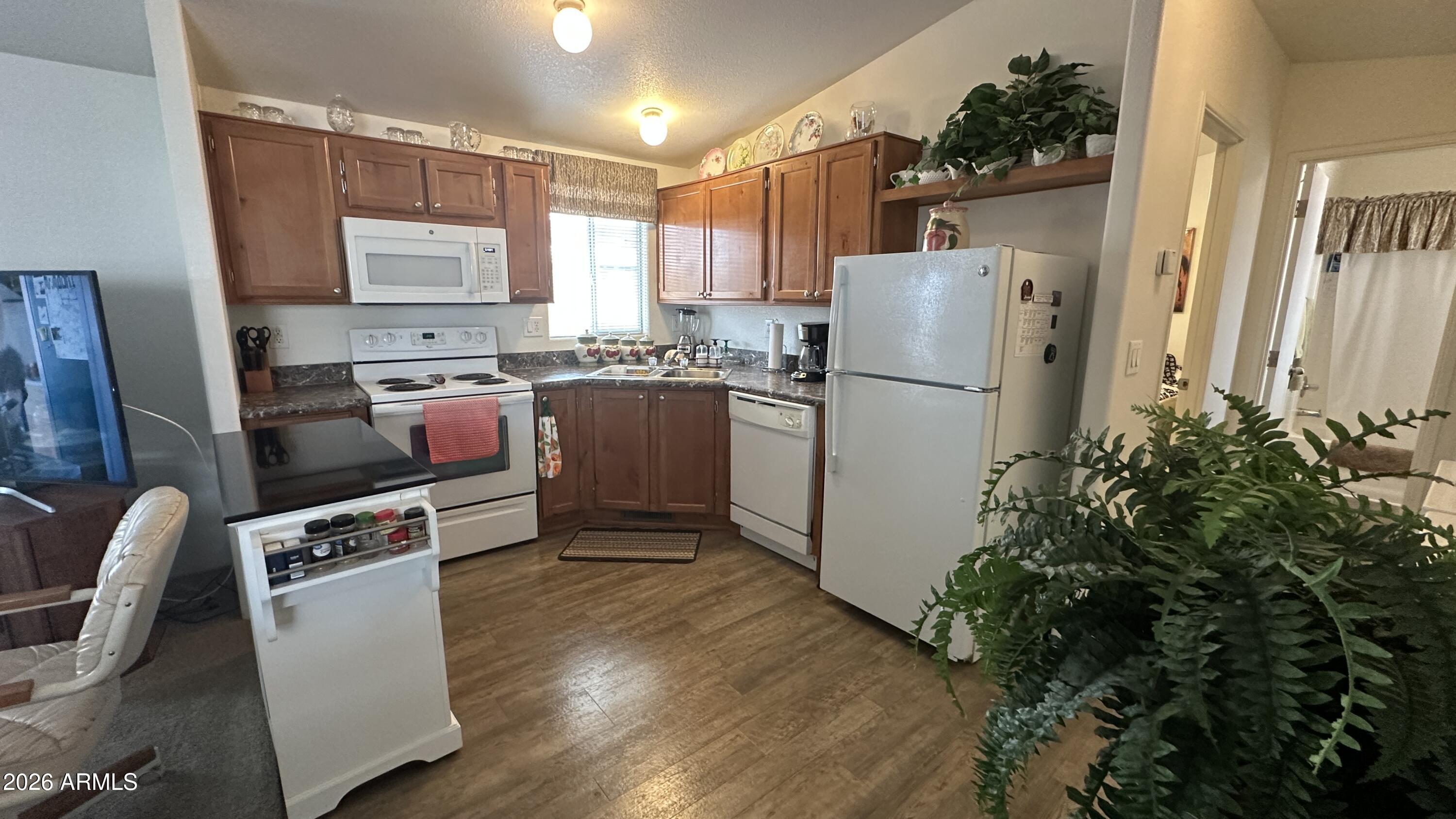 834 South Meridian Road, Unit 174 Apache Junction, AZ 85120 - Photo 38 of 56 a kitchen with stainless steel appliances a refrigerator sink and wooden floor