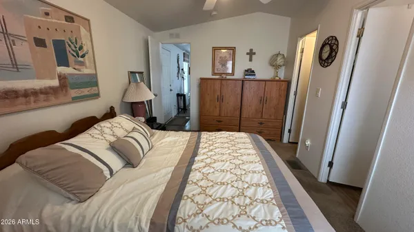 a bed sitting in a bedroom next to a window with desk and chair