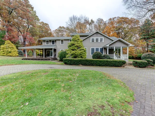 a front view of a house with a yard and trees