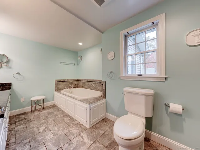 a bathroom with a toilet a sink and a window