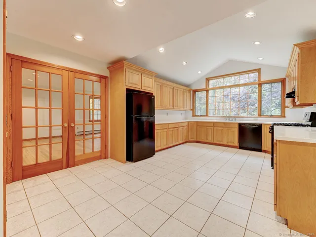 a large kitchen with stainless steel appliances granite countertop a refrigerator and a stove top oven