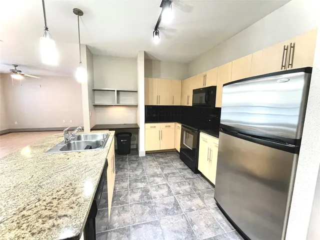 a kitchen with kitchen island a counter top space cabinets and stainless steel appliances