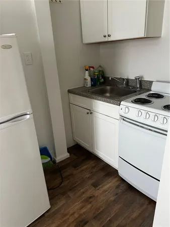 a kitchen with a white stove top oven and sink