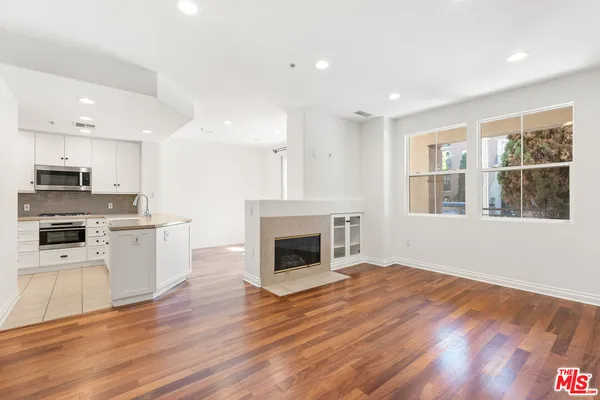 a view of kitchen with granite countertop kitchen island wooden floors and stainless steel appliances