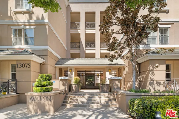 a front view of a building with outdoor seating and a potted plant
