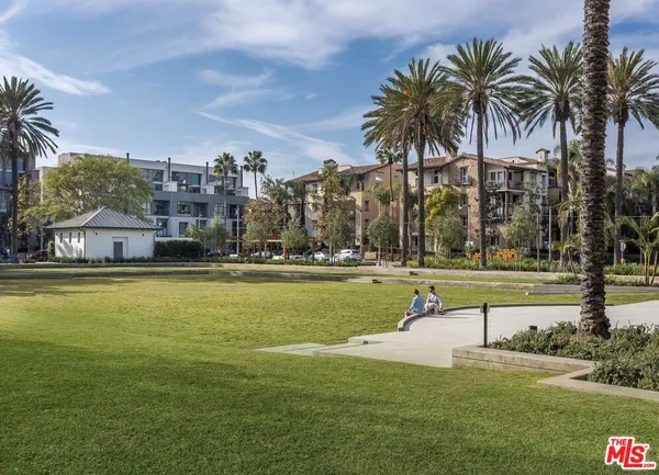 a view of a swimming pool with a yard and palm trees