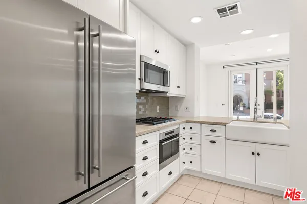 a kitchen with white cabinets and white appliances
