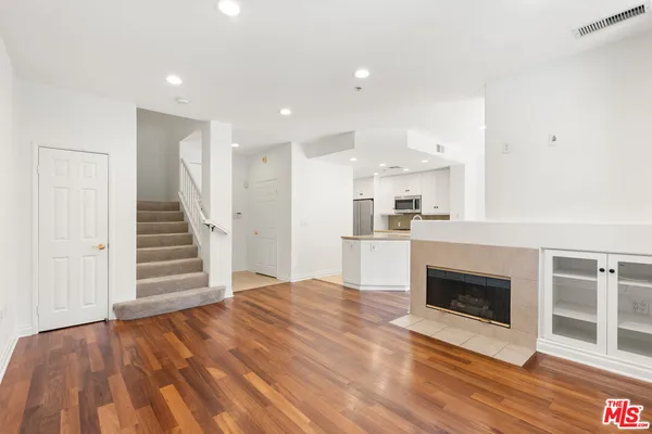 a view of a kitchen with wooden floor and electronic appliances