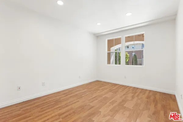 a view of empty room with wooden floor