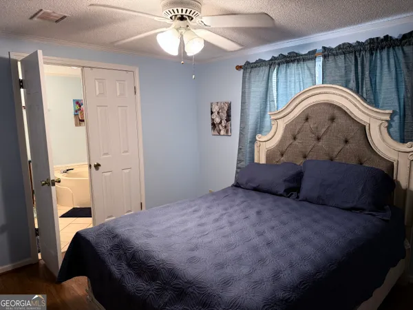 a spacious bedroom with a bed and a chandelier
