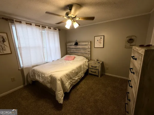a bedroom with a bed and a flat tv screen on the dresser
