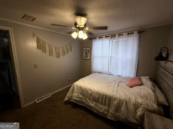 a bedroom with a bed and a ceiling fan