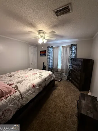 a spacious bedroom with a bed and a chandelier