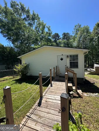 a view of a house with backyard and sitting area
