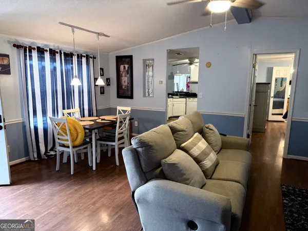 a living room with furniture a dining table and a chandelier