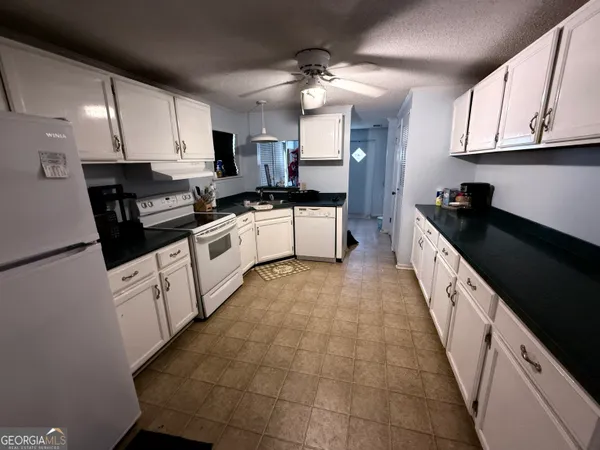 a large white kitchen with lots of appliances