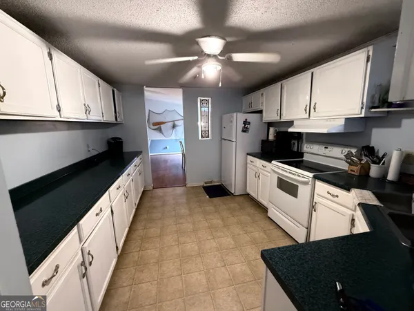 a kitchen with granite countertop a stove sink and cabinets