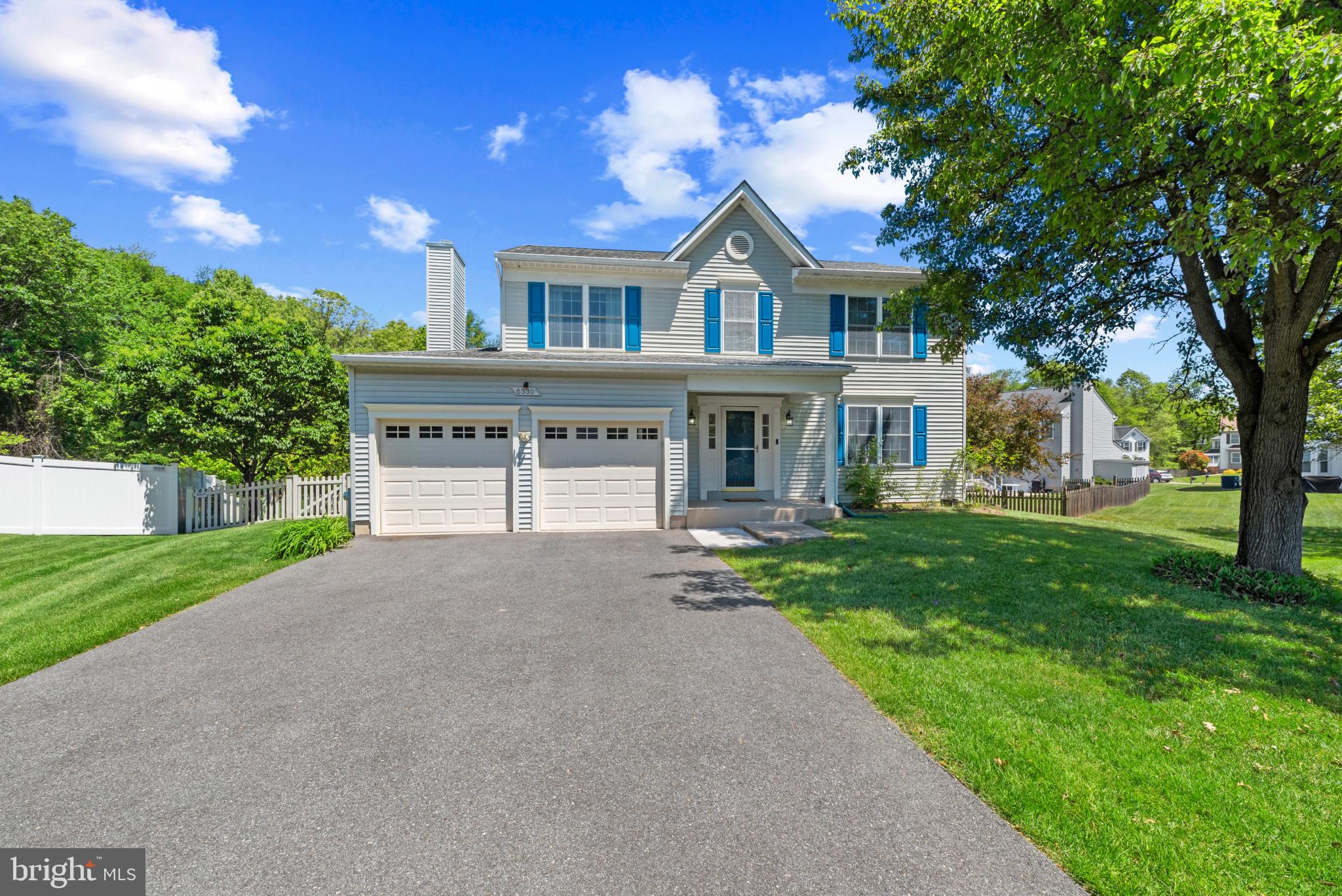 a front view of a house with yard and green space