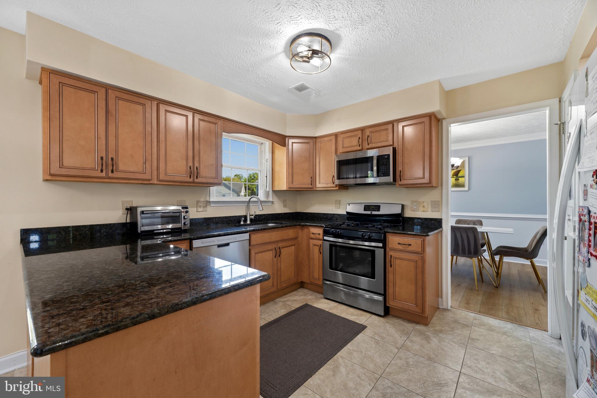 6330 Hanover Crossing Way Hanover, MD 21076 - Photo 7 of 32 a kitchen with granite countertop a stove sink and microwave