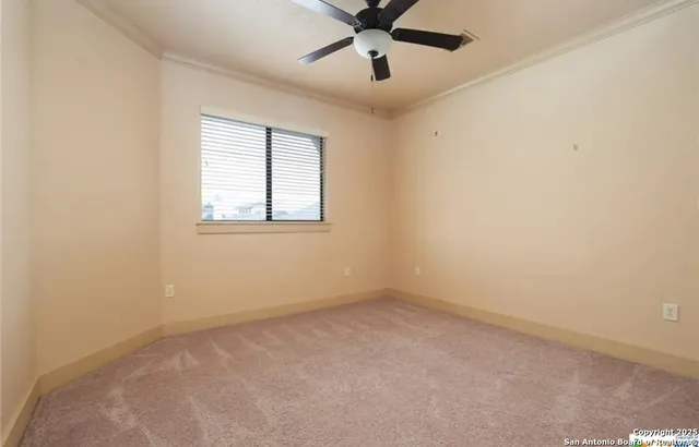 an empty room with a window and a fan