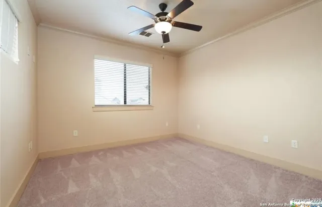 an empty room with a window and a fan