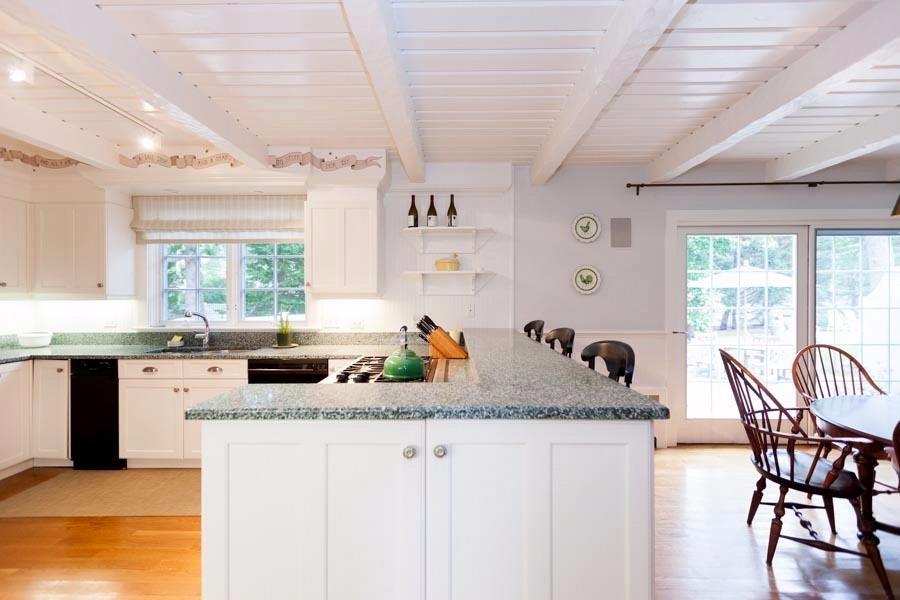 14 Bayview Road Osterville, MA 02655 - Photo 17 of 32 a kitchen with granite countertop a stove a sink a dining table and chairs