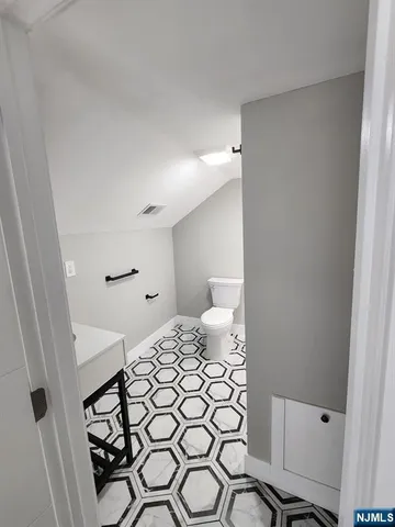 a bedroom with a bed and a lamp on the dresser