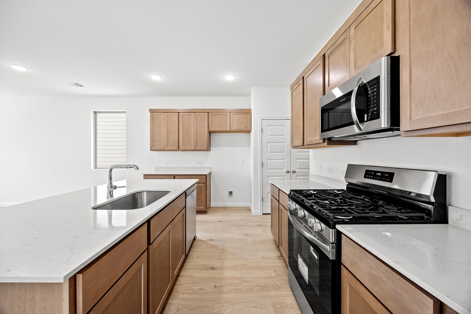 200 Hornet Street Elgin, TX 78621 - Photo 12 of 39 a kitchen with stainless steel appliances a sink a stove a microwave and wooden cabinets