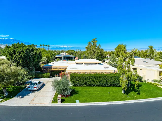 a white house with a yard and plants