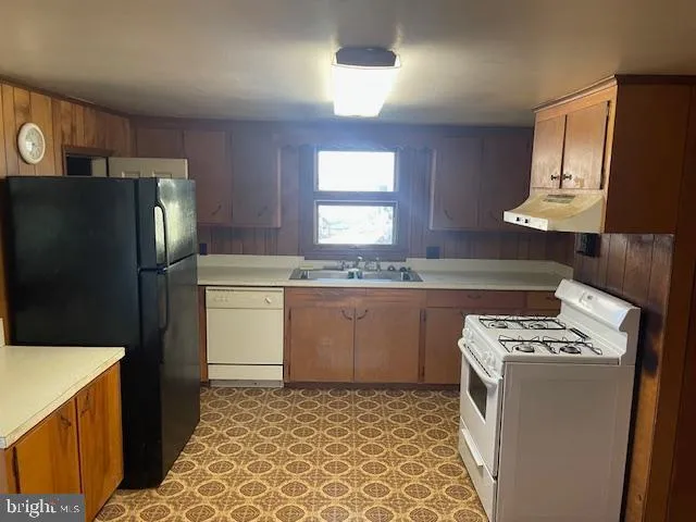 a kitchen with a stove a refrigerator and a sink