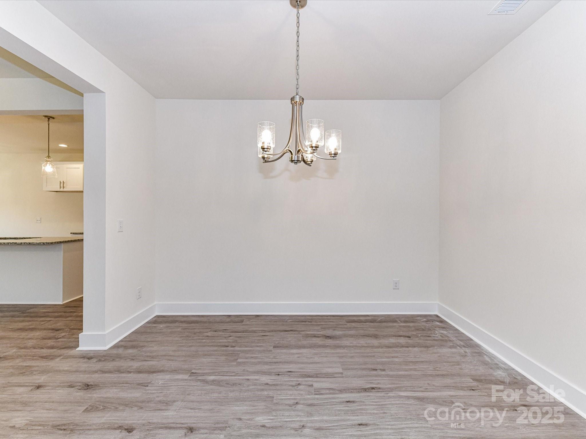 5609 Morgan Mill Road Monroe, NC 28110 - Photo 13 of 22 a view of a room with wooden floor staircase and a kitchen
