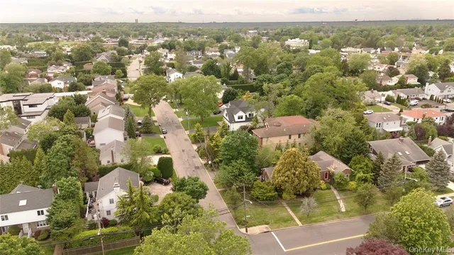 an aerial view of residential houses with outdoor space and trees