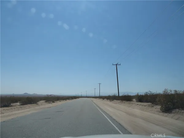a view of a dry yard with wooden fence