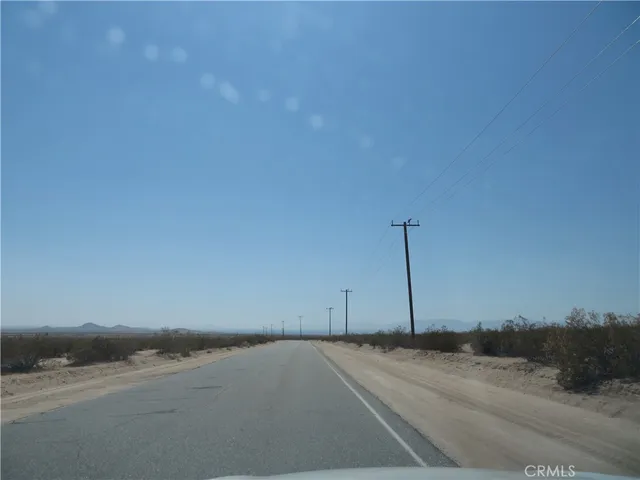 a view of a dry yard with wooden fence