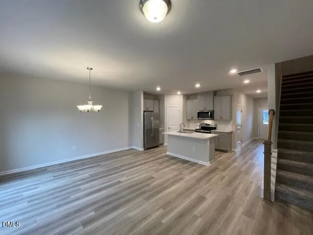 a kitchen that has a sink a stove and chairs