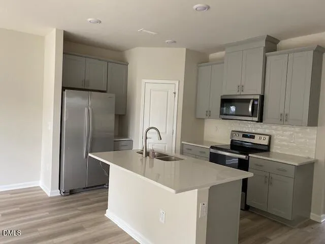 a kitchen with stainless steel appliances granite countertop a sink a refrigerator and a stove