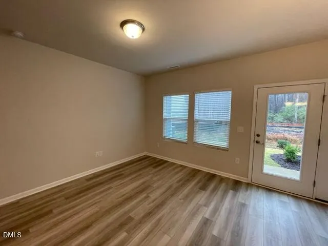 a view of a room with wooden floor chandelier and windows