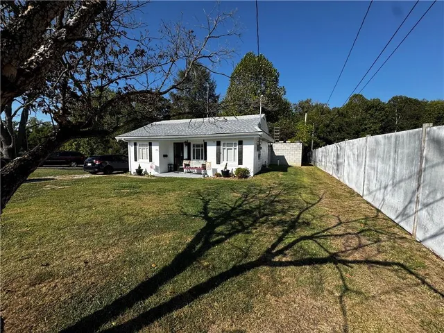 a view of a white house with a yard