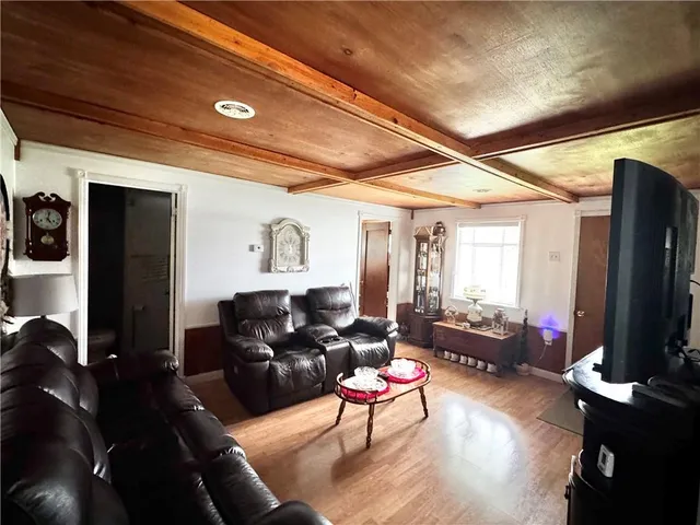 a living room with furniture a flat screen tv and a large window
