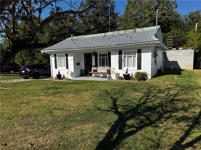 a front view of a house with a garden and trees