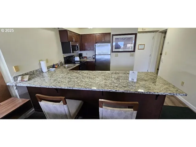 a view of kitchen island a sink and wooden floor
