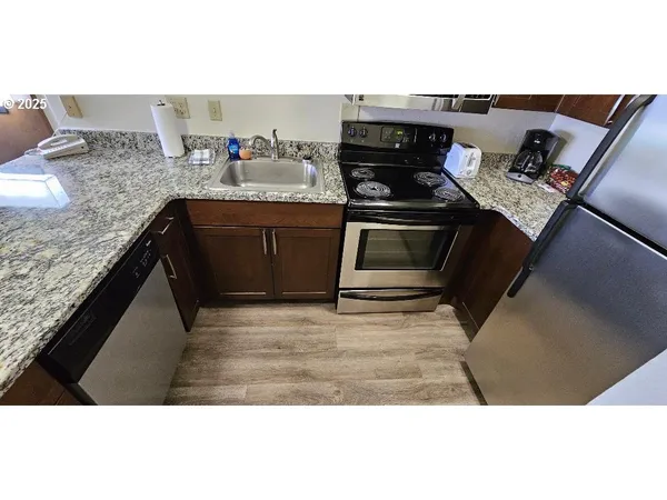 a kitchen with stainless steel appliances granite countertop a stove a sink and a microwave