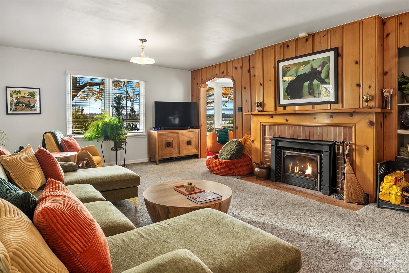 8025 West Mercer Way Mercer Island, WA 98040 - Photo 24 of 36 a living room with furniture a fireplace and a flat screen tv