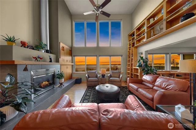 a living room with furniture a fireplace and a large window