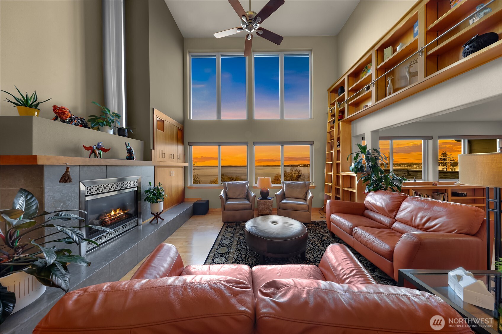 a living room with furniture a fireplace and a large window